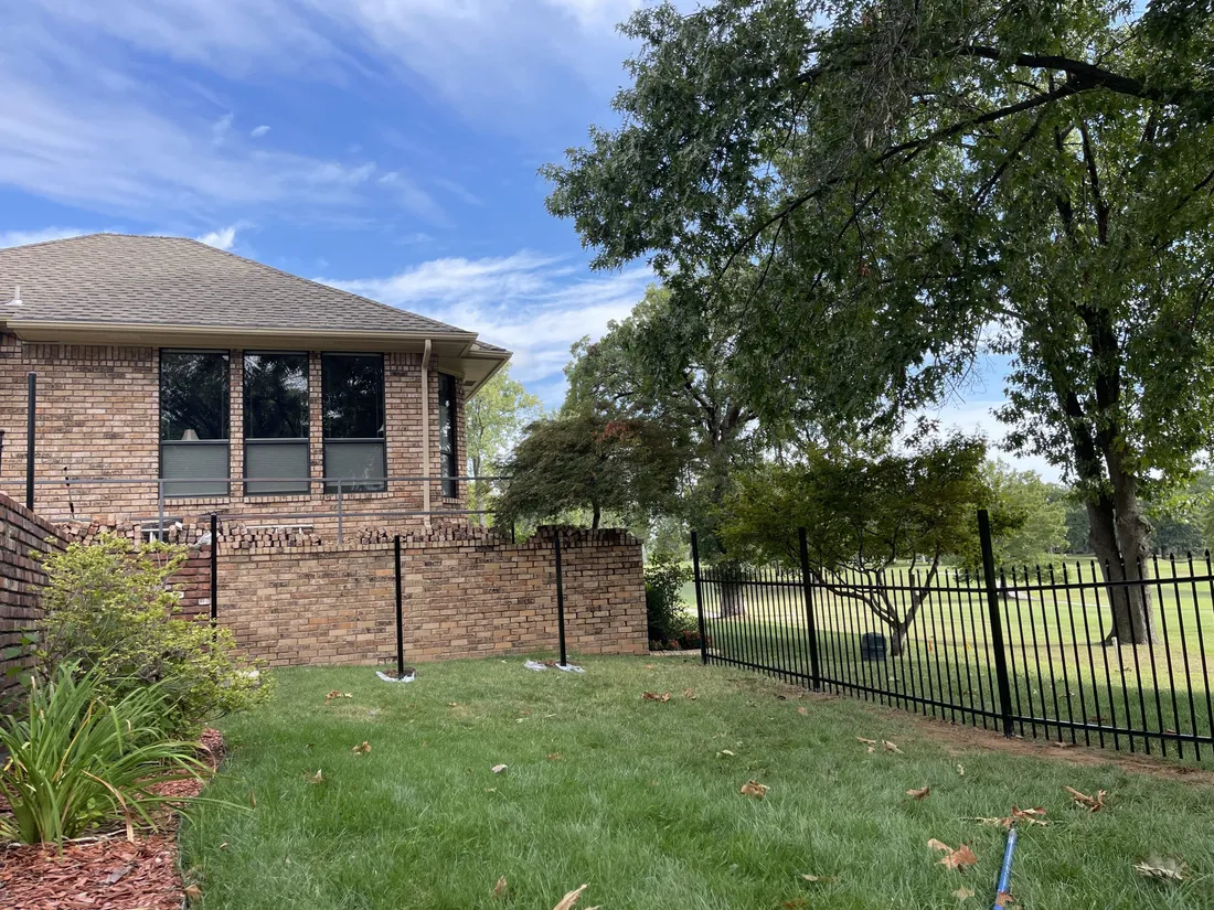 Black ornamental aluminum fence on a brick wall, an ornamental fence in Tulsa, OK