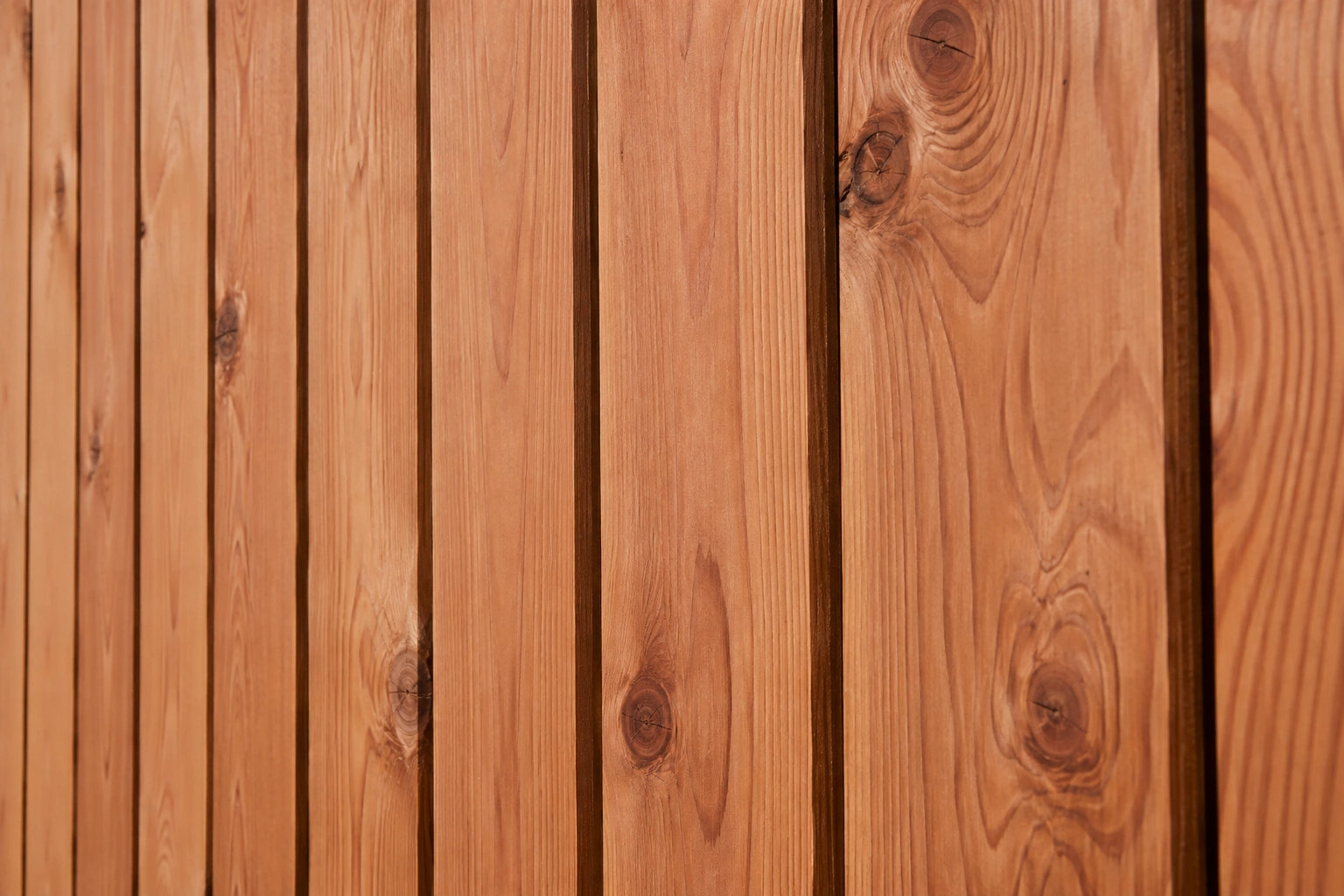 Close-up of warm red cedar fence boards showing natural wood grain