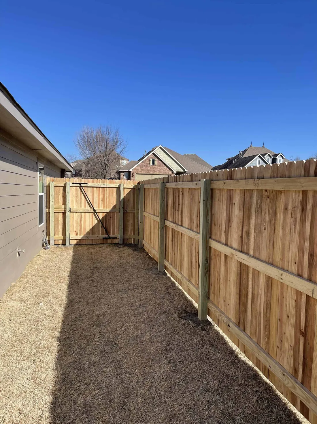 Cedar privacy fence beside a brick home, a backyard privacy fence Tulsa, OK