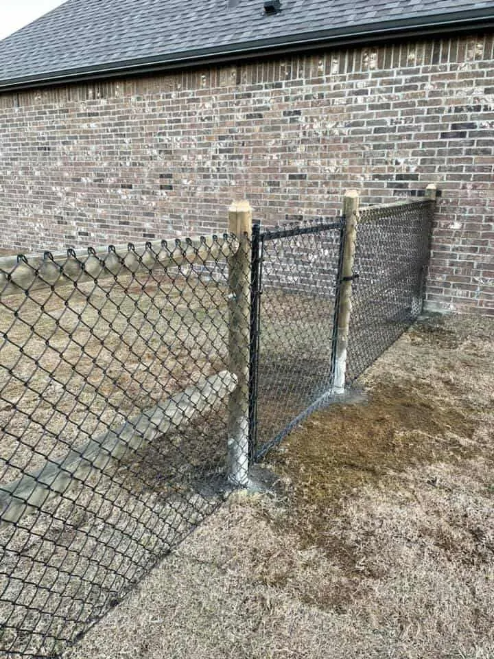 Black vinyl-coated chain link fence and gate around a residential yard in Tulsa, OK