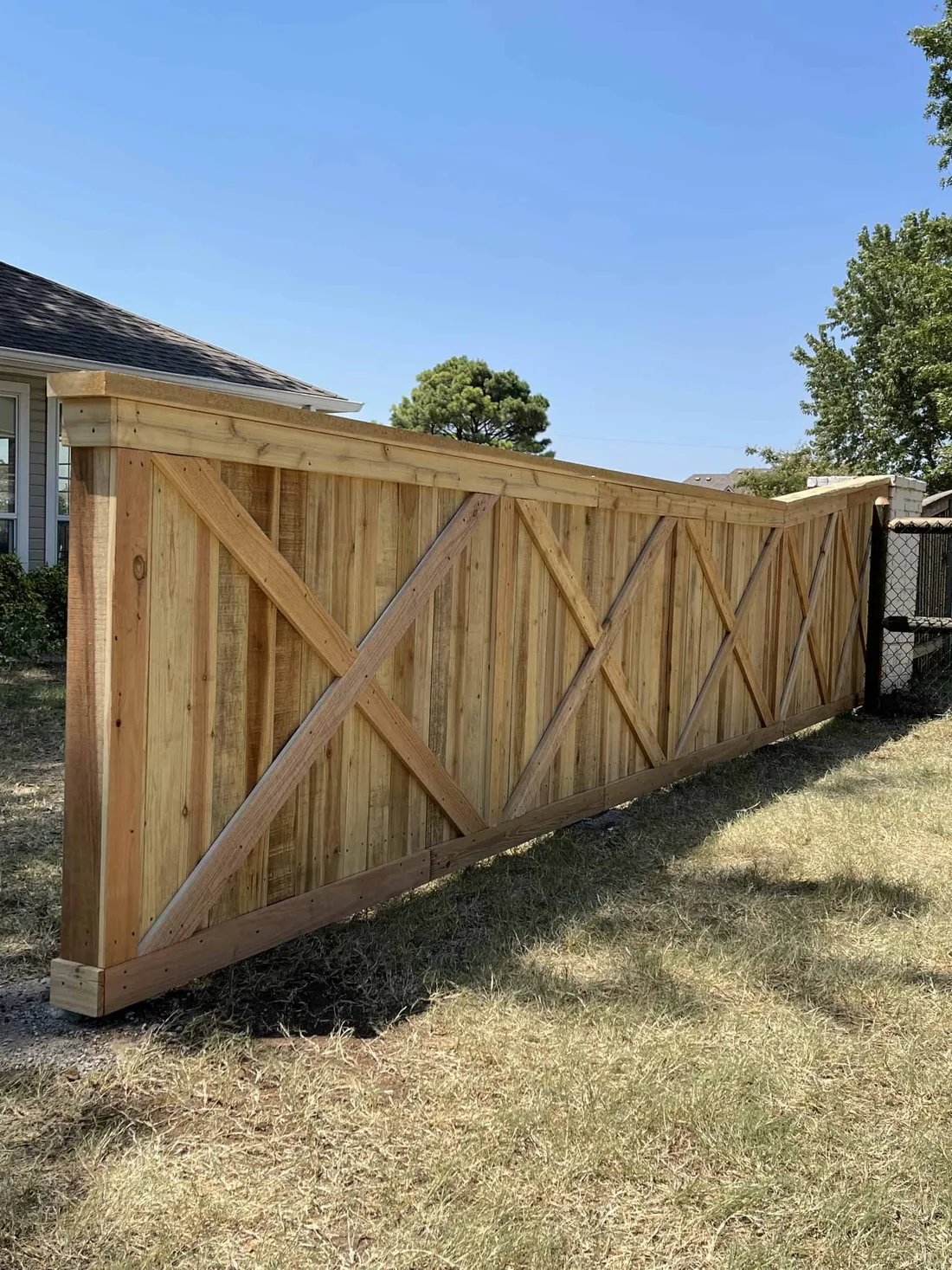 Long cedar crossbuck fence across a backyard, a decorative fence style in Tulsa, OK