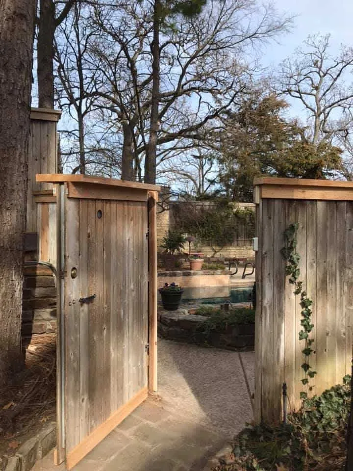 Cedar courtyard gate standing open to a backyard, a custom gate built in Tulsa, OK