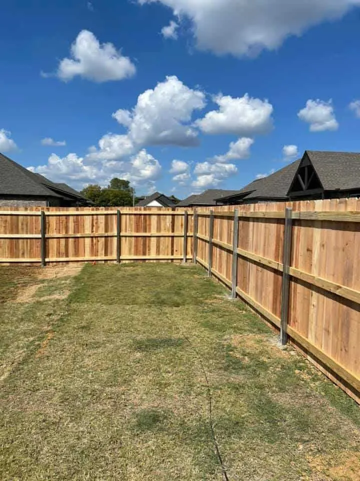 Tall cedar privacy fence under a cloudy sky, a privacy fence Tulsa, OK build
