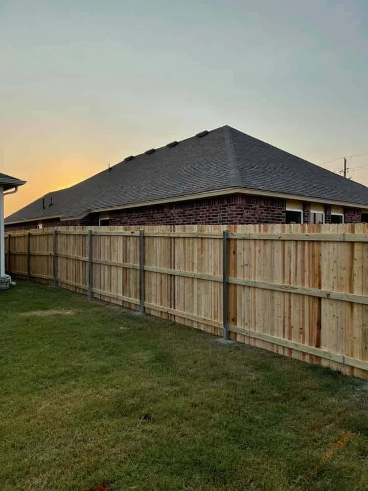 Cedar privacy fence framing a brick home at sunset, among our privacy fence styles Tulsa, OK