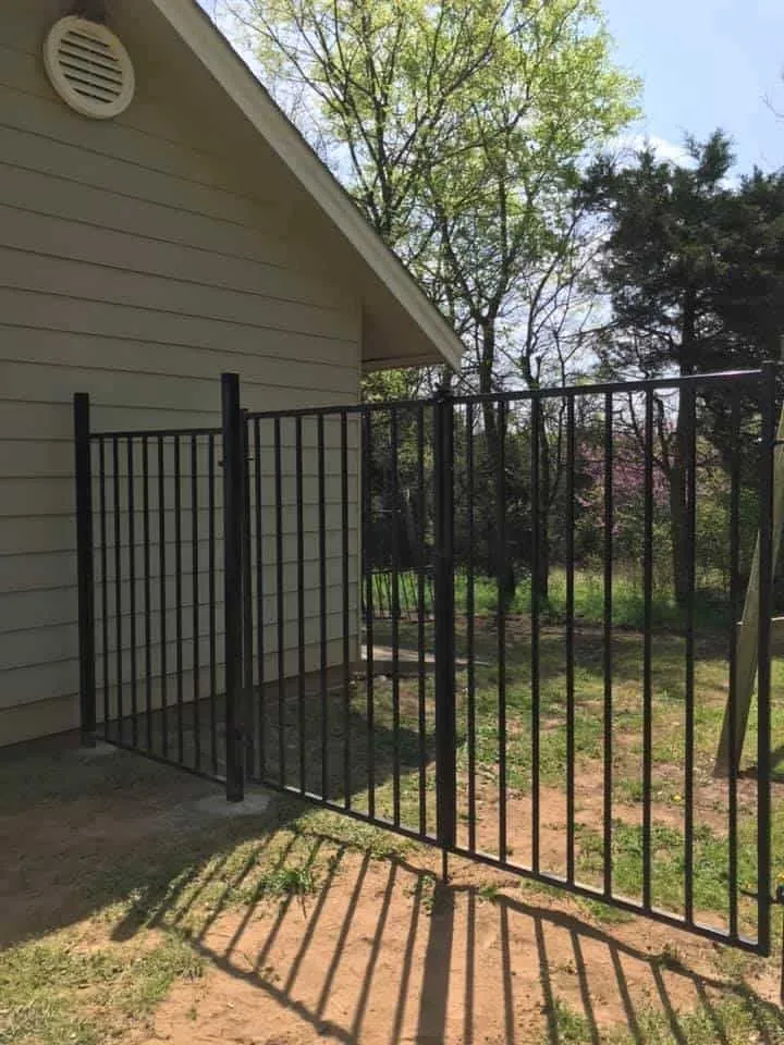 Black ornamental aluminum fence and gate beside a home, an ornamental fence in Tulsa, OK