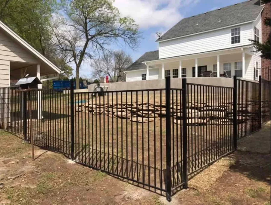 Black ornamental iron fence and gate around a yard, an ornamental fence in Tulsa, OK