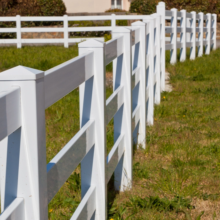 White vinyl ranch rail fence along a property line in Tulsa, OK