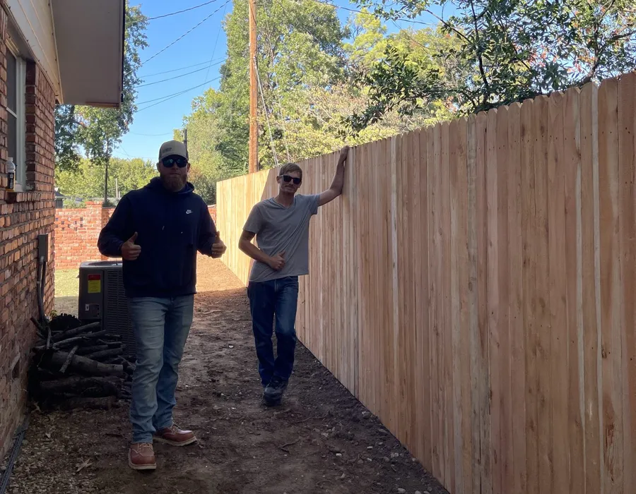 Setting cedar fence posts on a job for the best wood fence Tulsa, OK delivers