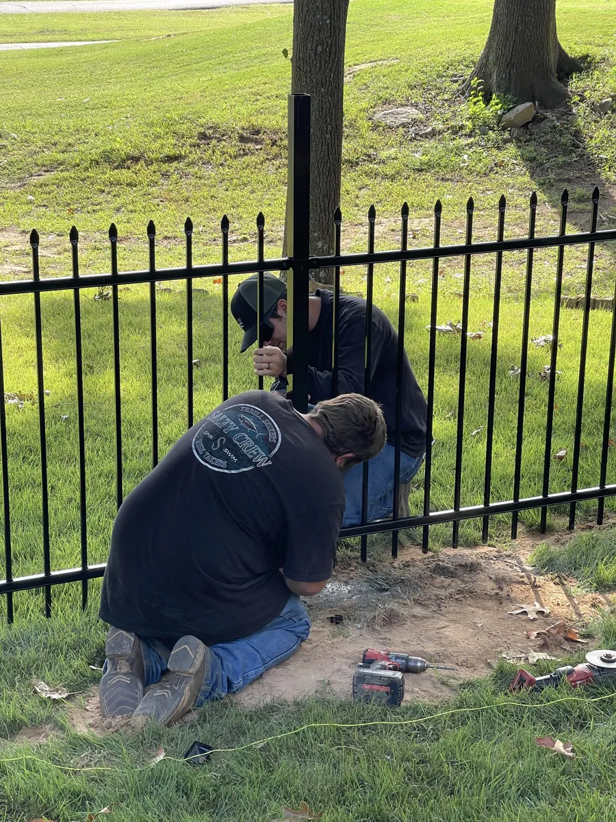 Completing a black ornamental iron fence, wrought iron fence installation near me Tulsa, OK