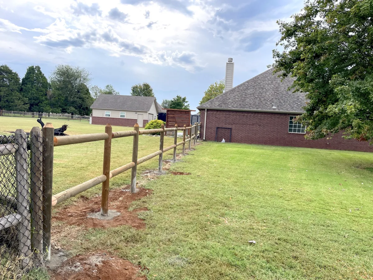 Wooden two-rail ranch fence beside a country home, a ranch fence in Tulsa, OK