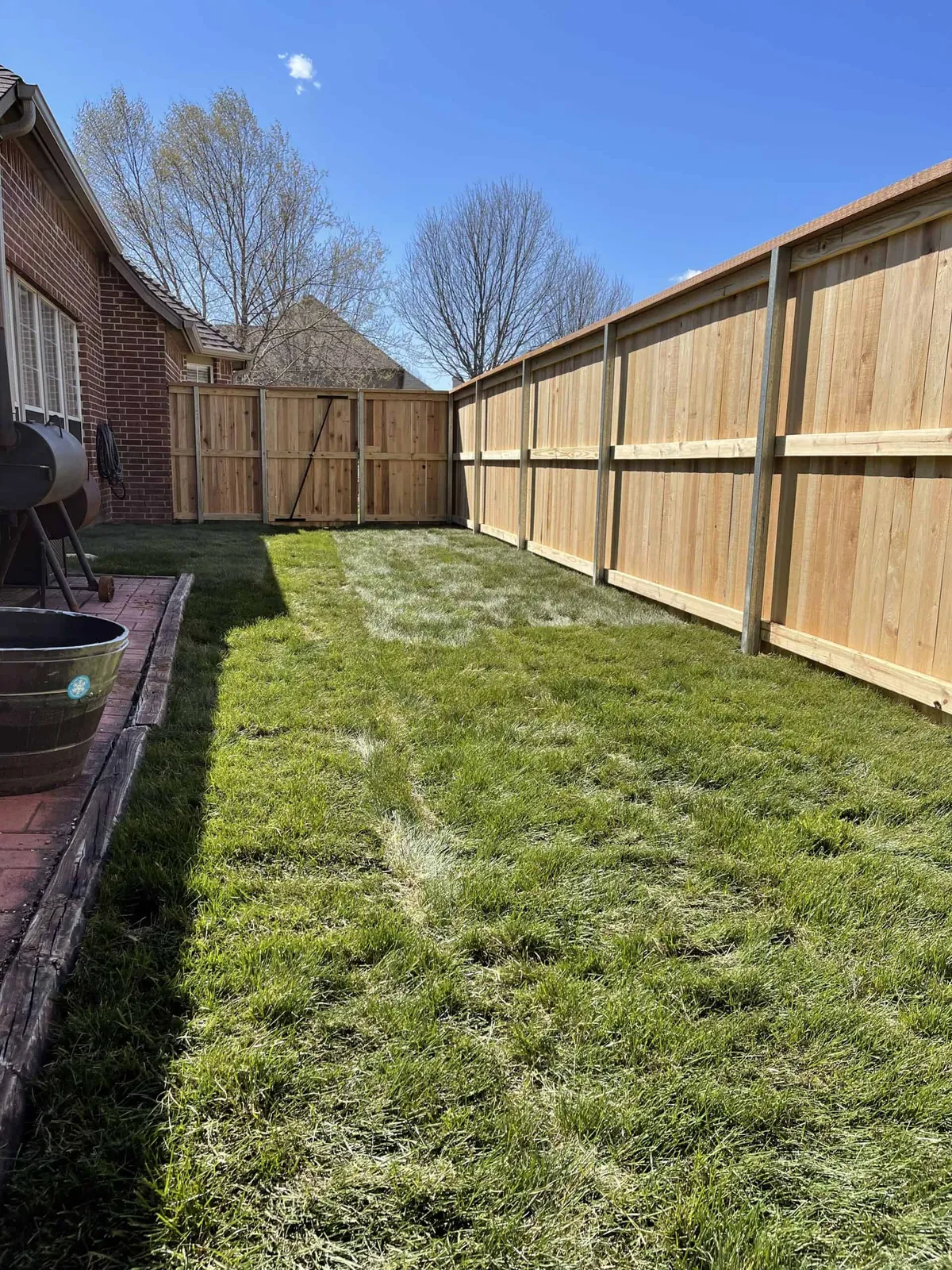 Cedar privacy fence along a backyard, residential fencing Tulsa, OK families trust