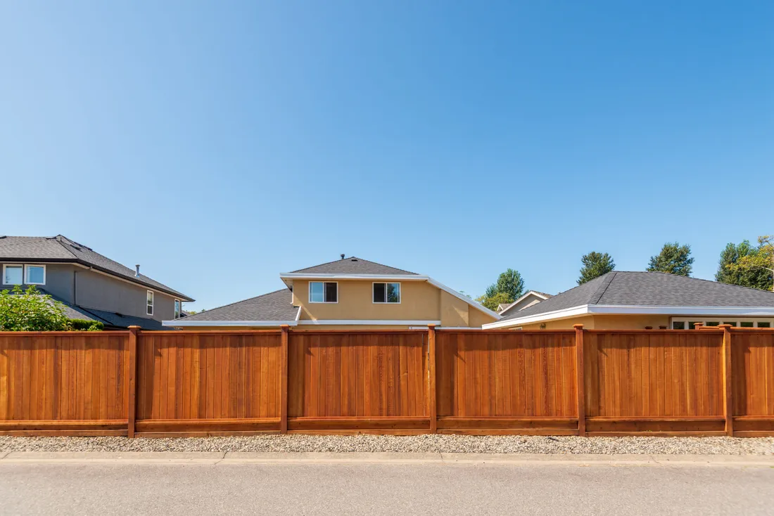 Stained cedar privacy fence lining a street, a privacy fence Tulsa, OK install